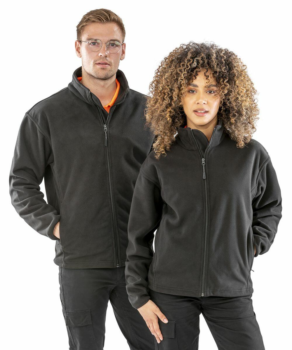 Two people wearing dark Result R109A zip-up fleece jackets, standing against a plain background. The person on the left has glasses, and both have a hand in a pocket.