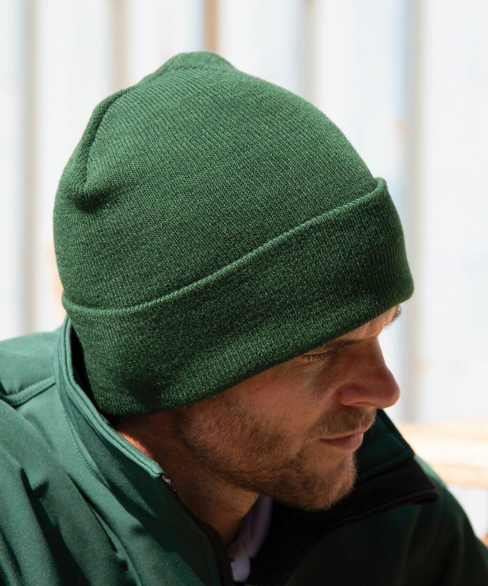 A person wearing a dark green Result RC029 and a matching green jacket looks down.