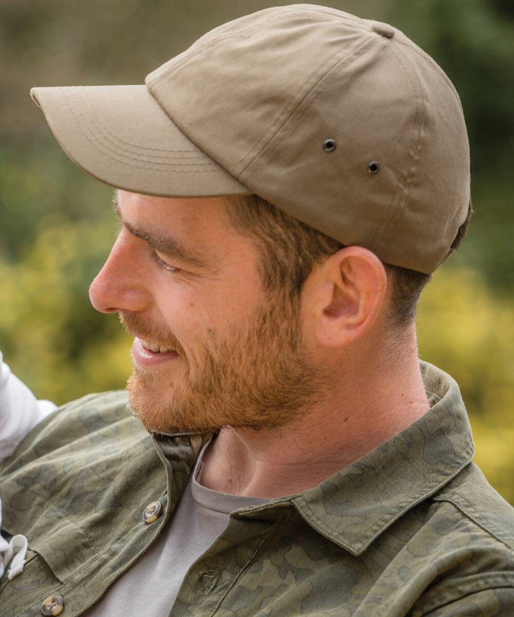 A man with a beard smiles while wearing a tan Result RC63X and a green camo jacket. He is looking to the left.