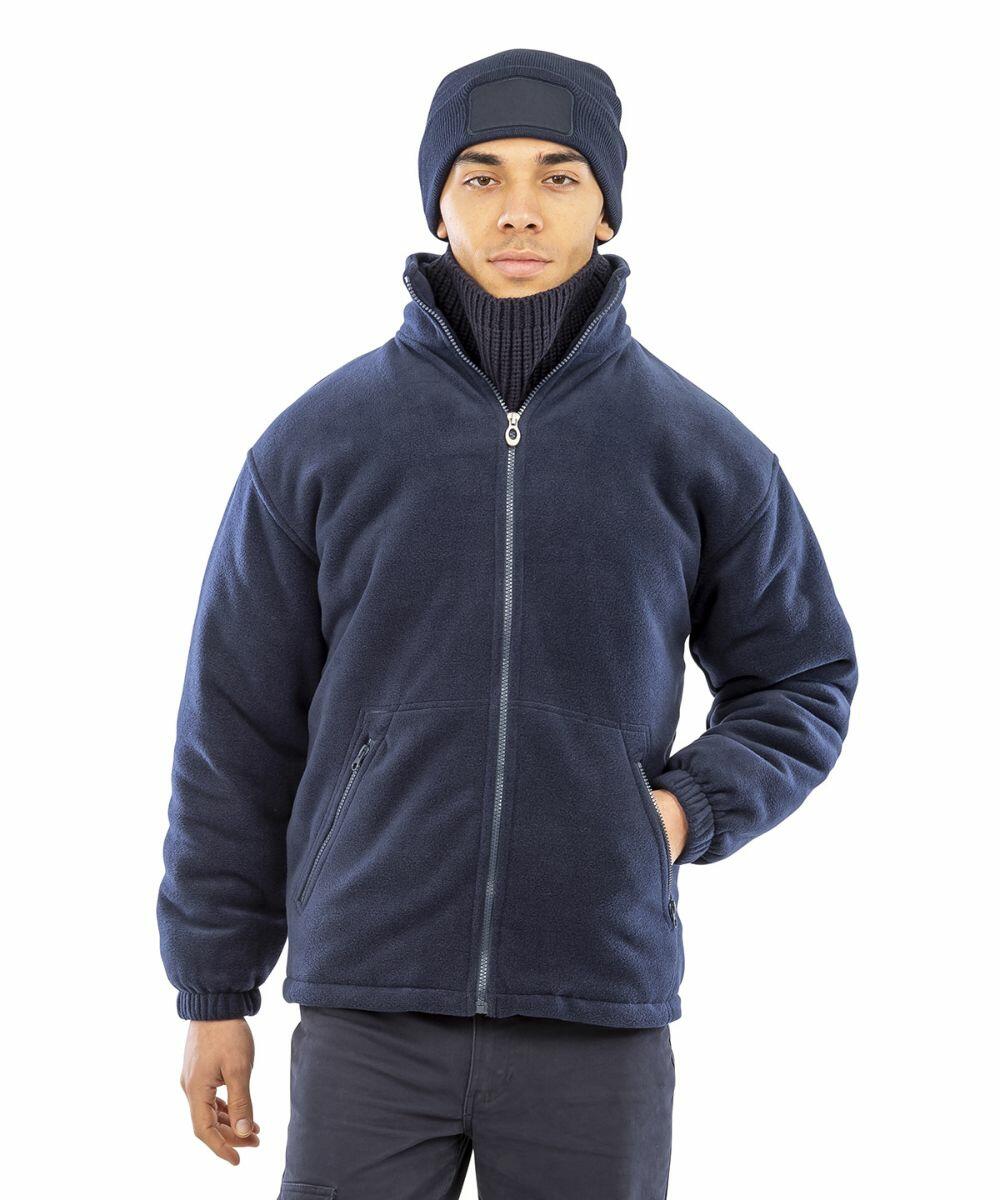 Person wearing a dark blue Result R219X zip-up jacket, a black turtleneck, and a matching dark blue beanie, standing against a white background.
