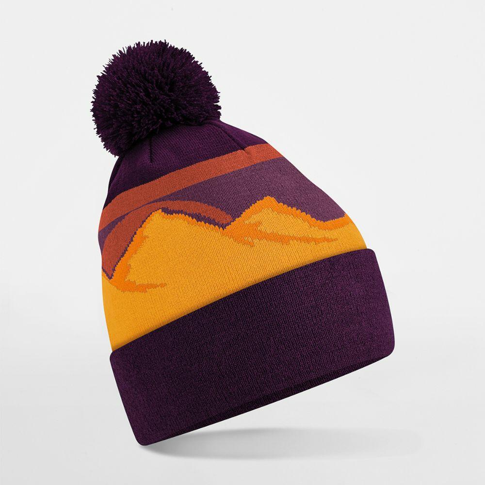 The Beechfield B395R is a knit beanie in purple and yellow, featuring a sunset mountain design and topped with a pom-pom.