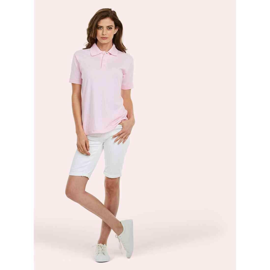A woman wearing a UC122 Pink Uneek Jersey polo shirt with White shorts