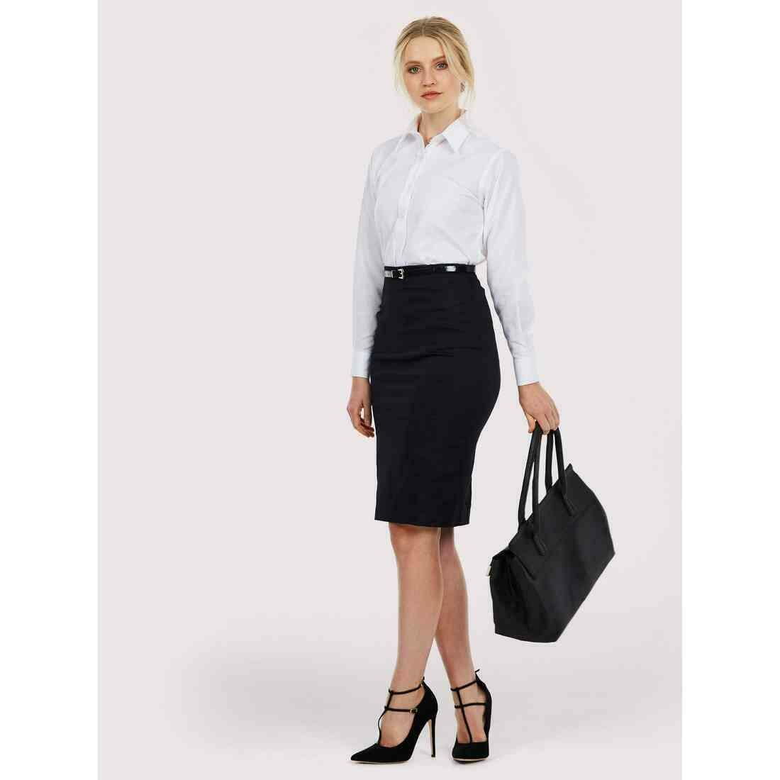 A woman wearing a UC703 White Uneek ladies pinpoint oxford L/S shirt with Black skirt