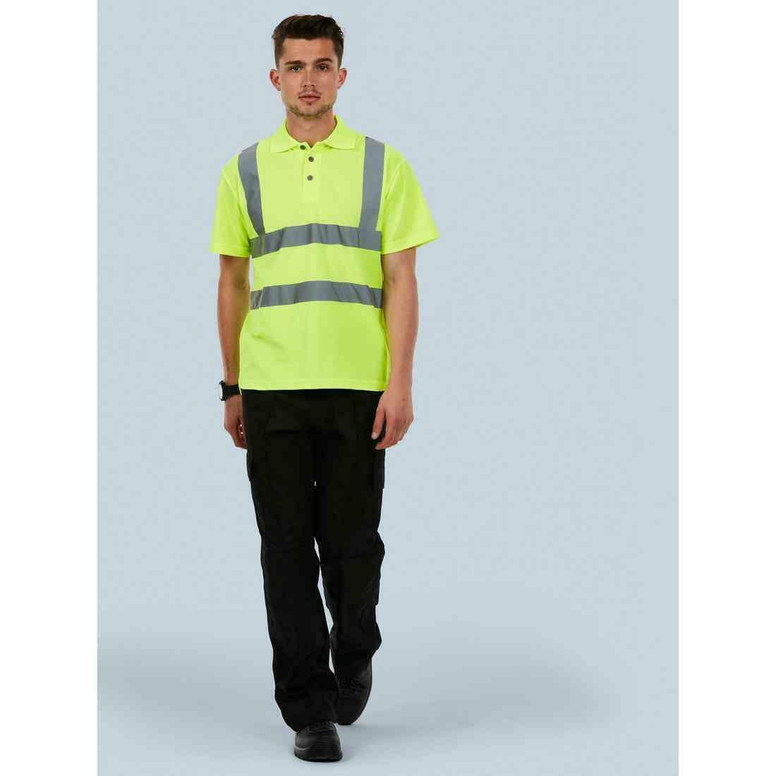 A man wearing a UC805 Yellow Uneek hi-viz polo with Black trousers