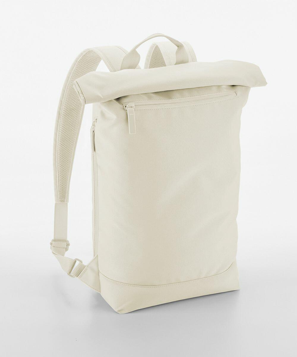 A minimalist beige backpack with a roll-top design, a front zippered pocket, and padded shoulder straps. The material has a smooth, clean finish. The Bagbase BG871 is standing upright on a plain white background.
