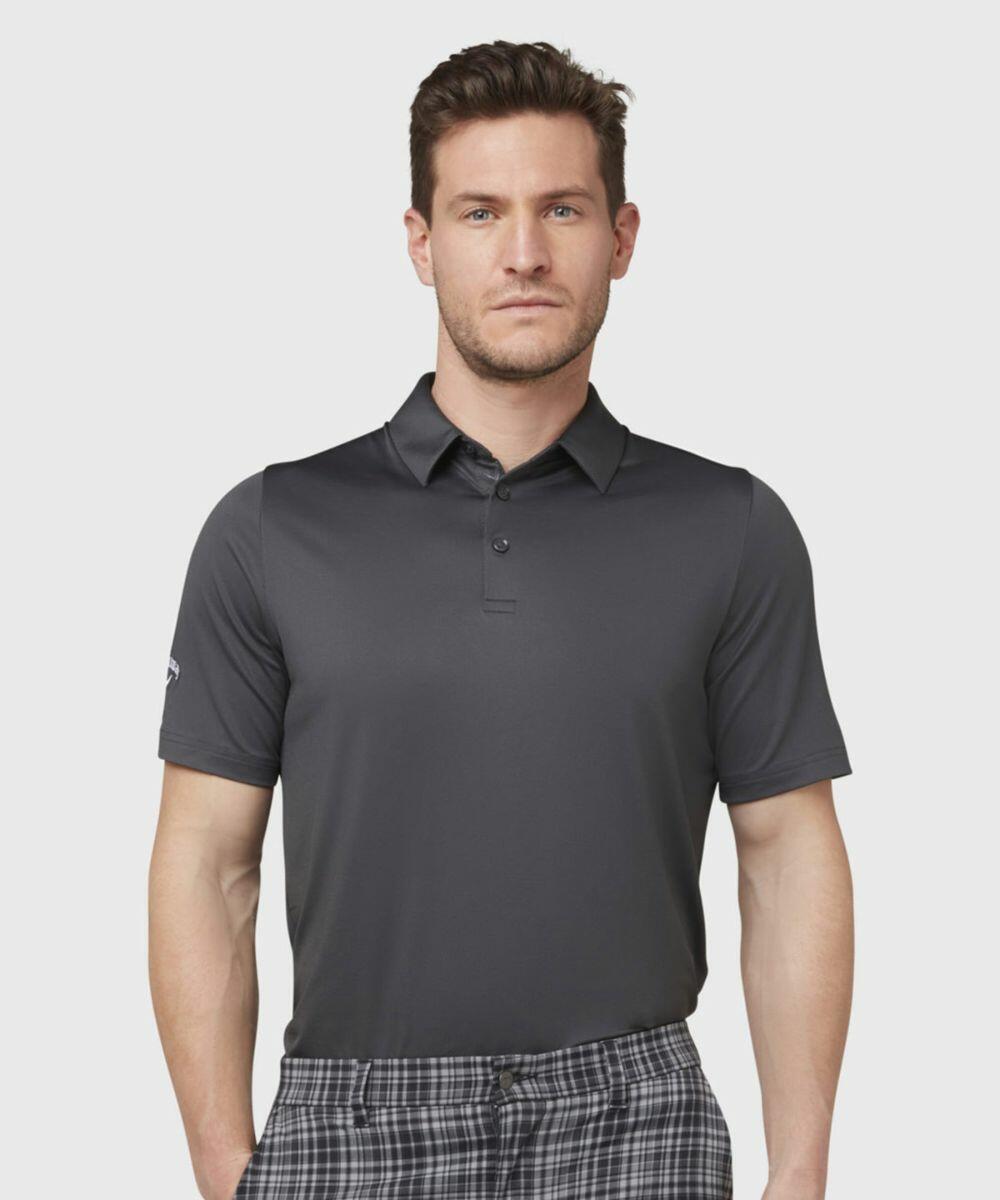 A man in a dark short-sleeve Callaway CW025 polo shirt and plaid pants stands against a plain background, looking directly at the camera.
