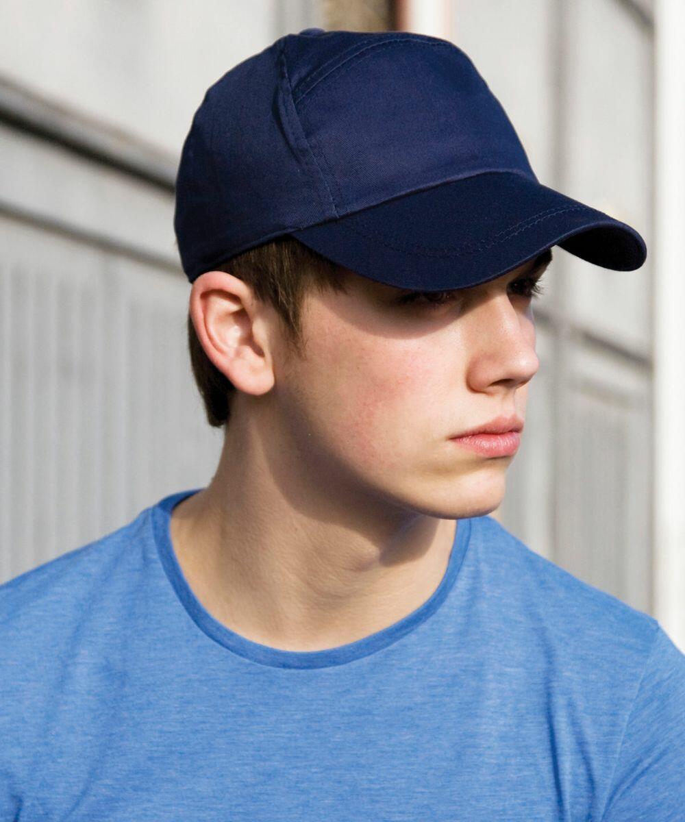 A person wearing a blue cap and blue shirt looks to the right, showcasing the Result RC02X.