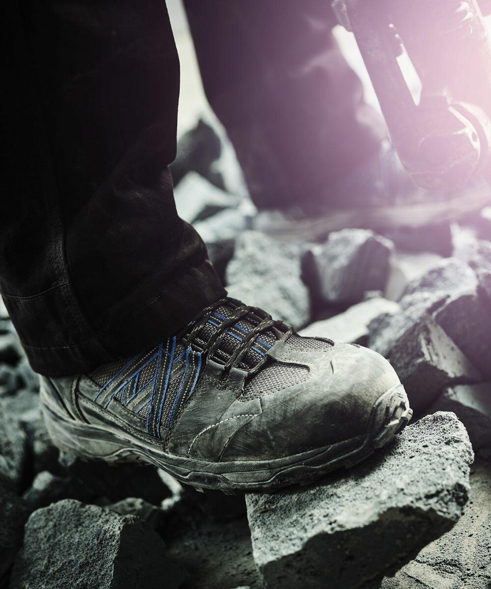 Person wearing Regatta RG566 rugged work boots standing on grey rubble.
