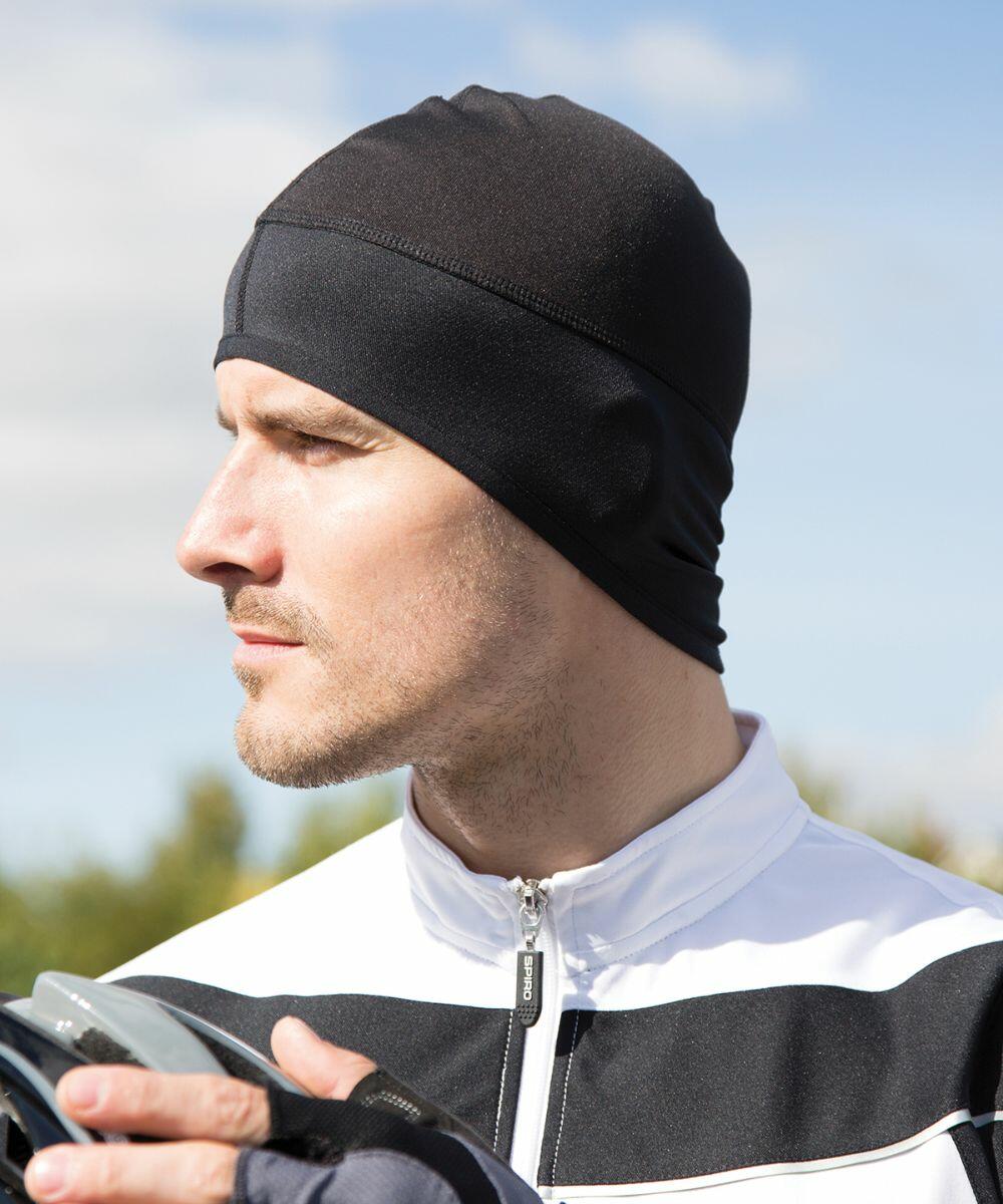 A man outdoors wearing a black Spiro S263X head covering and a white and black jacket looks into the distance.