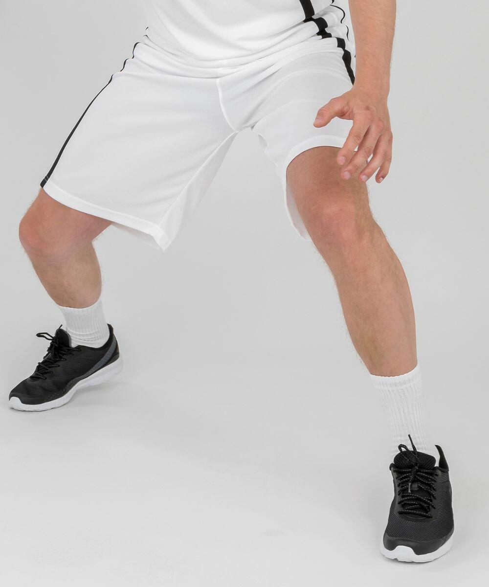 Person wearing white athletic shorts, white socks, and black Spiro S279M athletic shoes is in a sports stance. Only the lower half of the body is visible.