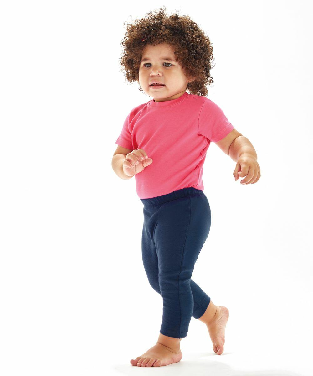 A young child with curly hair is walking, wearing a Babybugz BZ049 pink shirt and navy blue leggings.