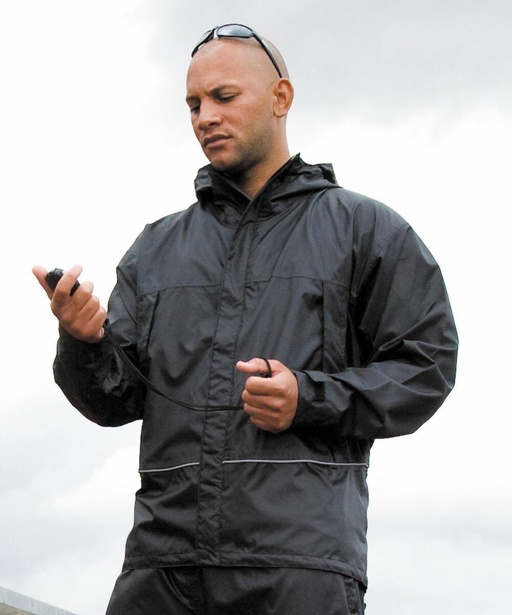 A person wearing a black windbreaker jacket and sunglasses looks at a handheld device, possibly an R155a by Result, against a cloudy sky background.