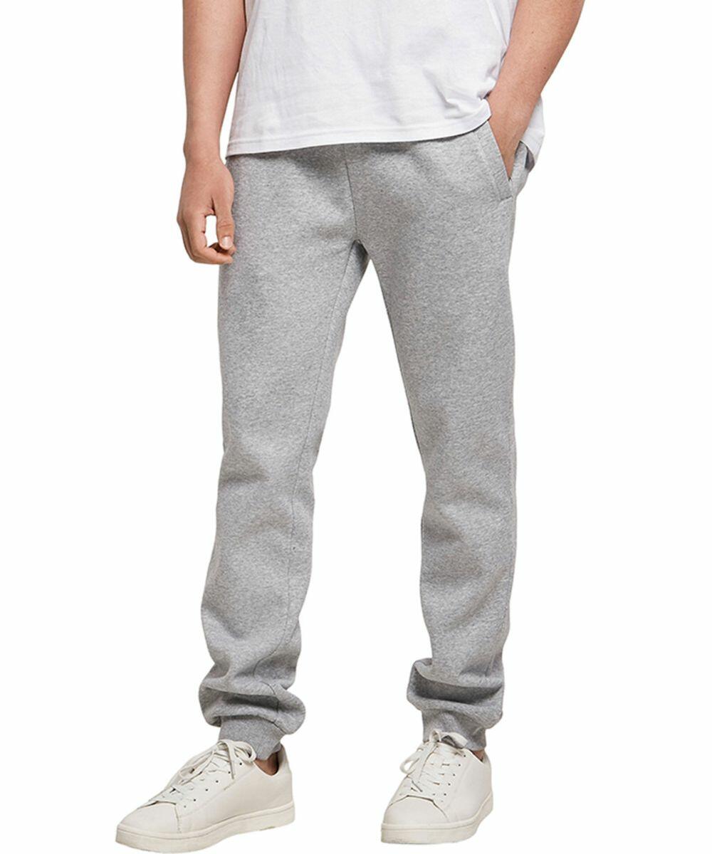 Person wearing a white T-shirt, light gray sweatpants, and Build Your Brand BY174 white sneakers, with hands partially in pockets.