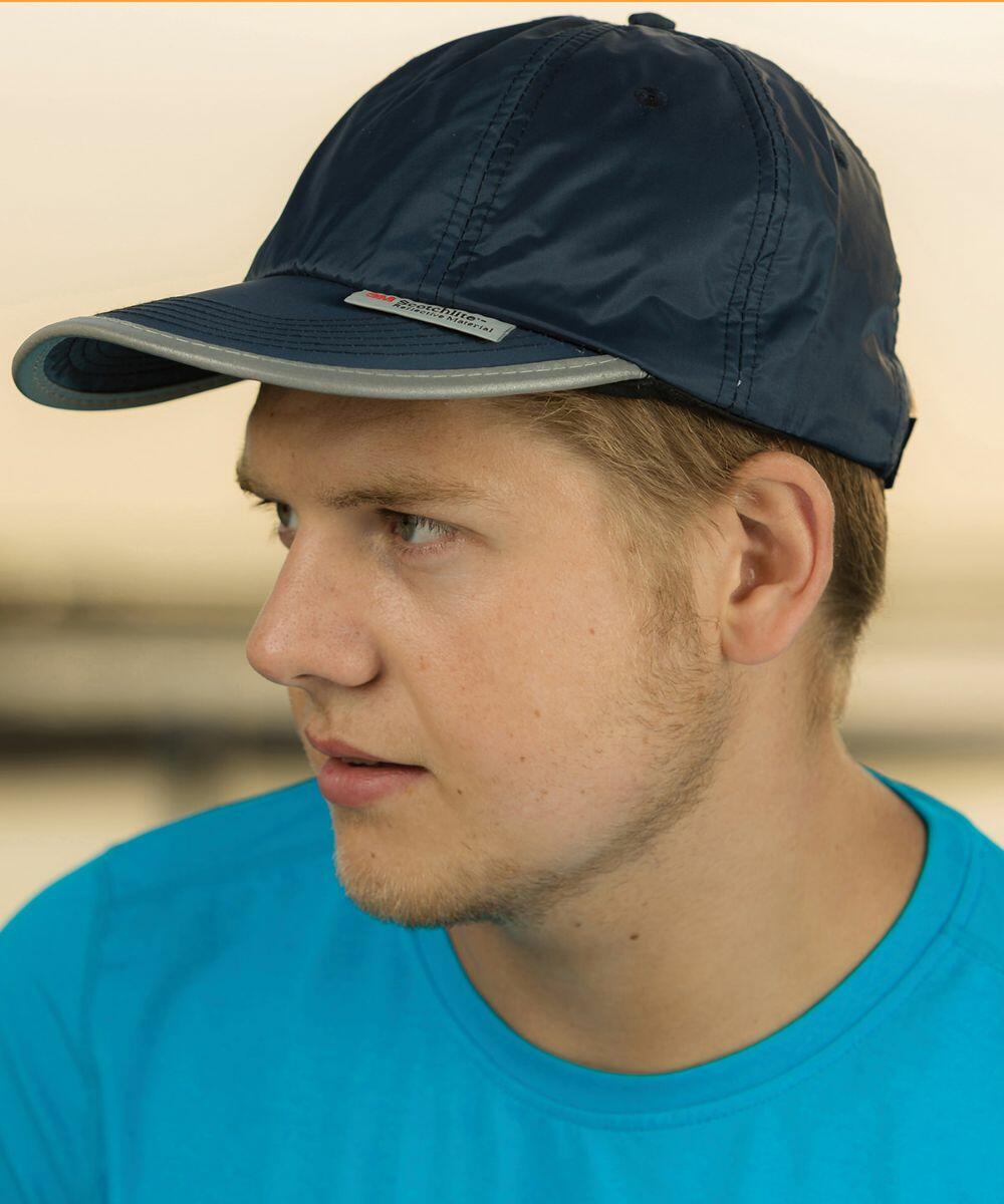 A person in a blue shirt and dark blue RC35X by Result cap looks to the side.