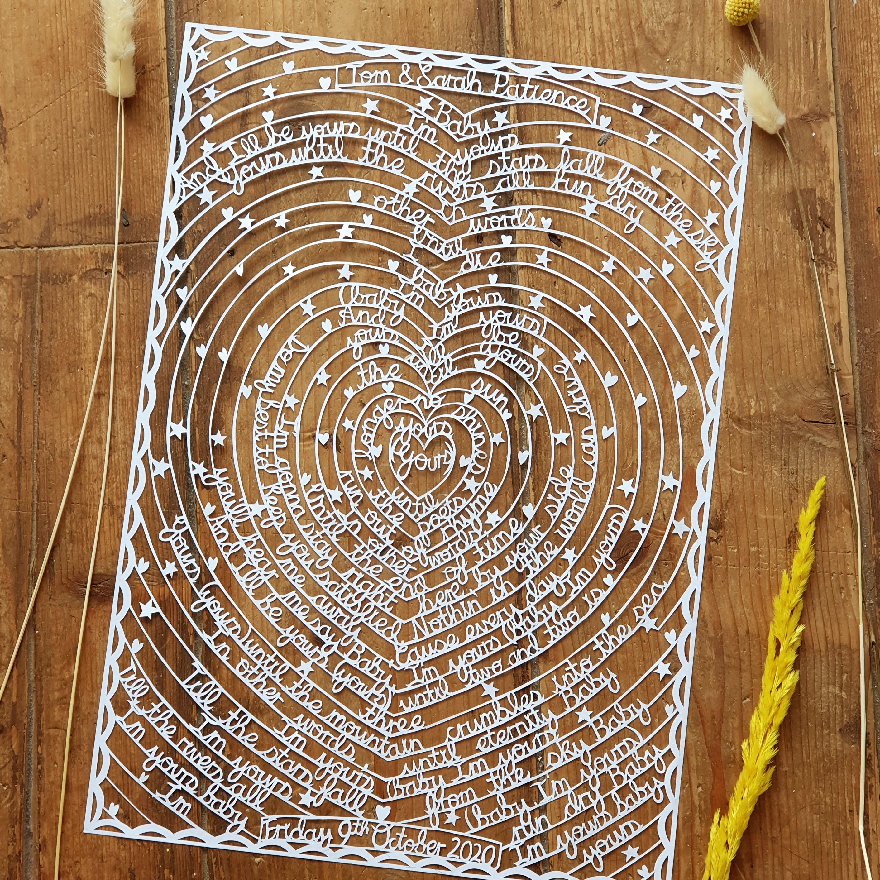 A paper cut featuring song lyrics or wedding vows