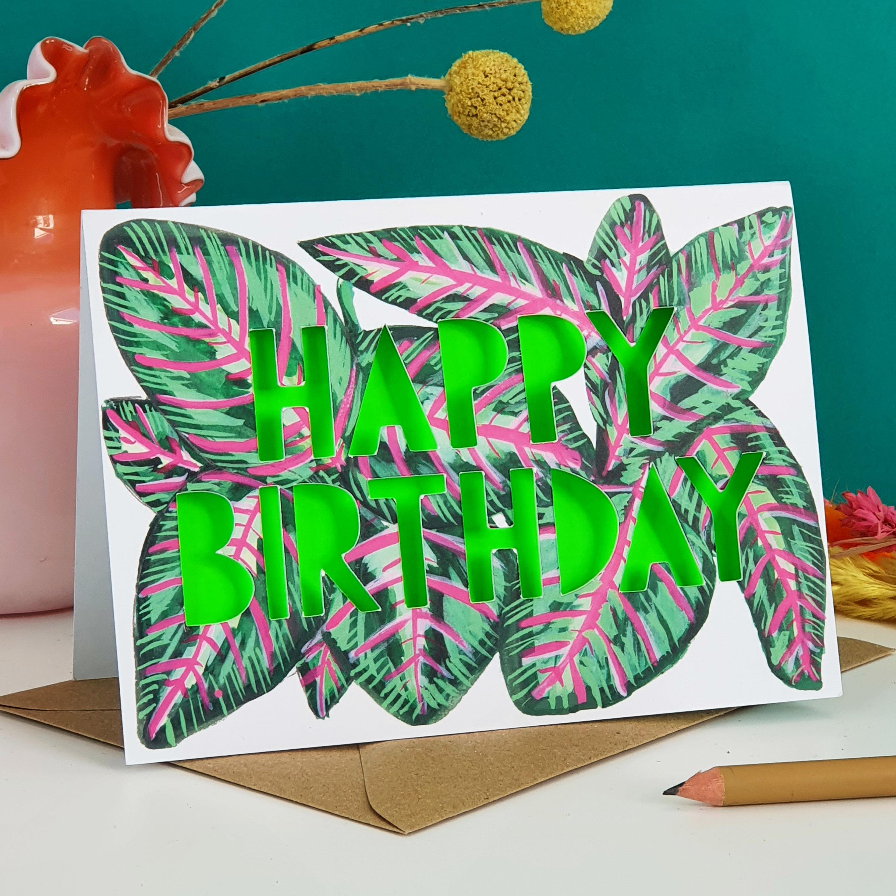 Paper cut card with 'Happy Birthday' typography on a printed stripy pink and green leaf 350 gsm card with neon green liner.