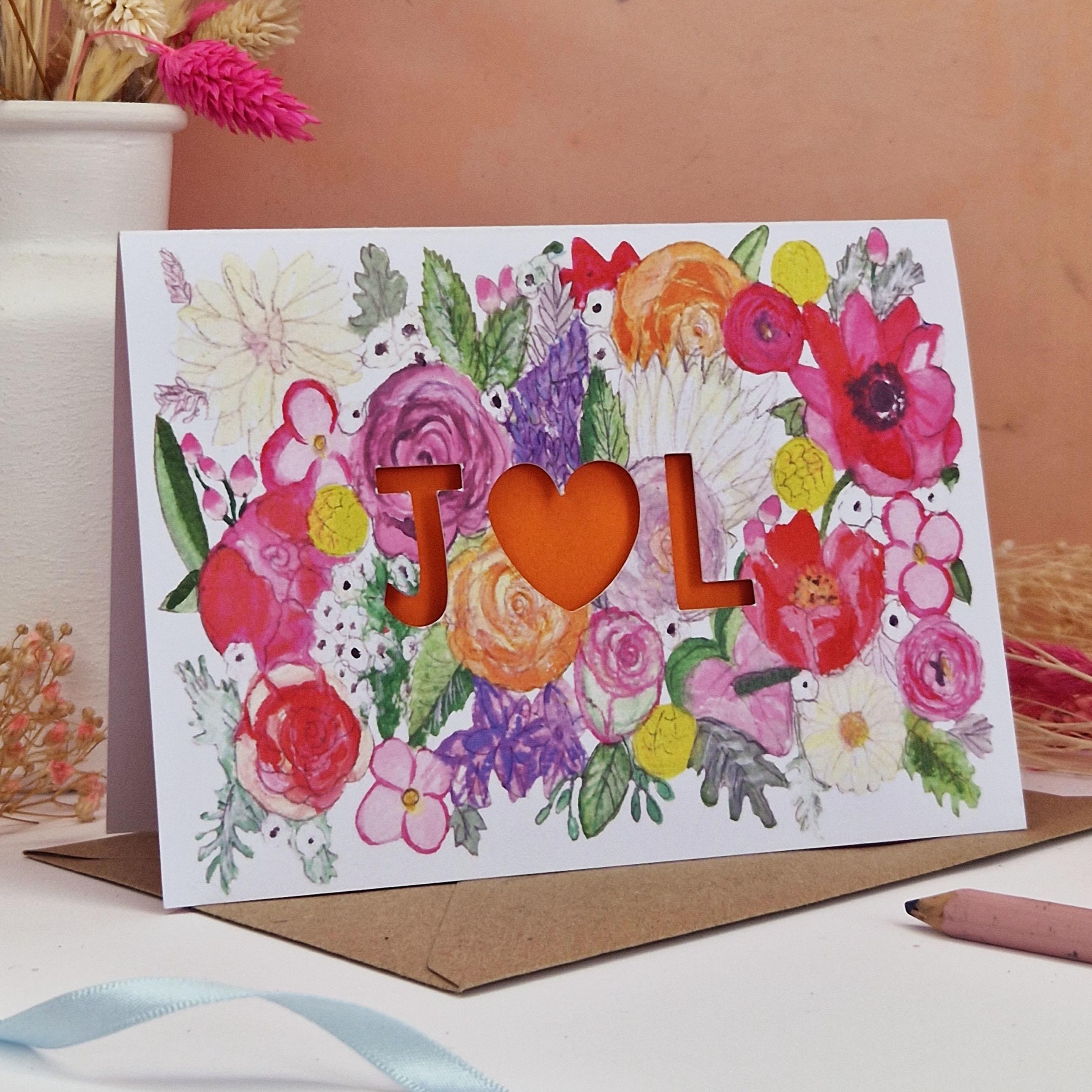Floral Card with Paper cut text that is personalised with Initials with bright floral background and pink paper liner inside.