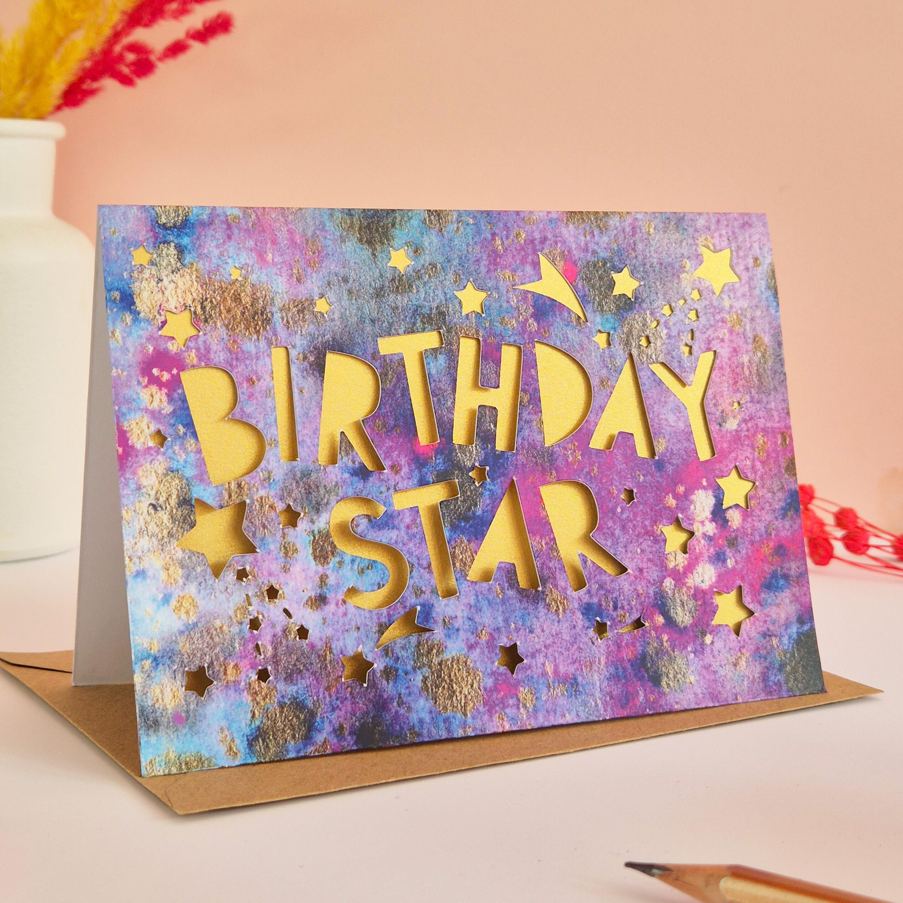Celestial themed birthday card with die cut Birthday Star text and stars with shimmering gold paper liner