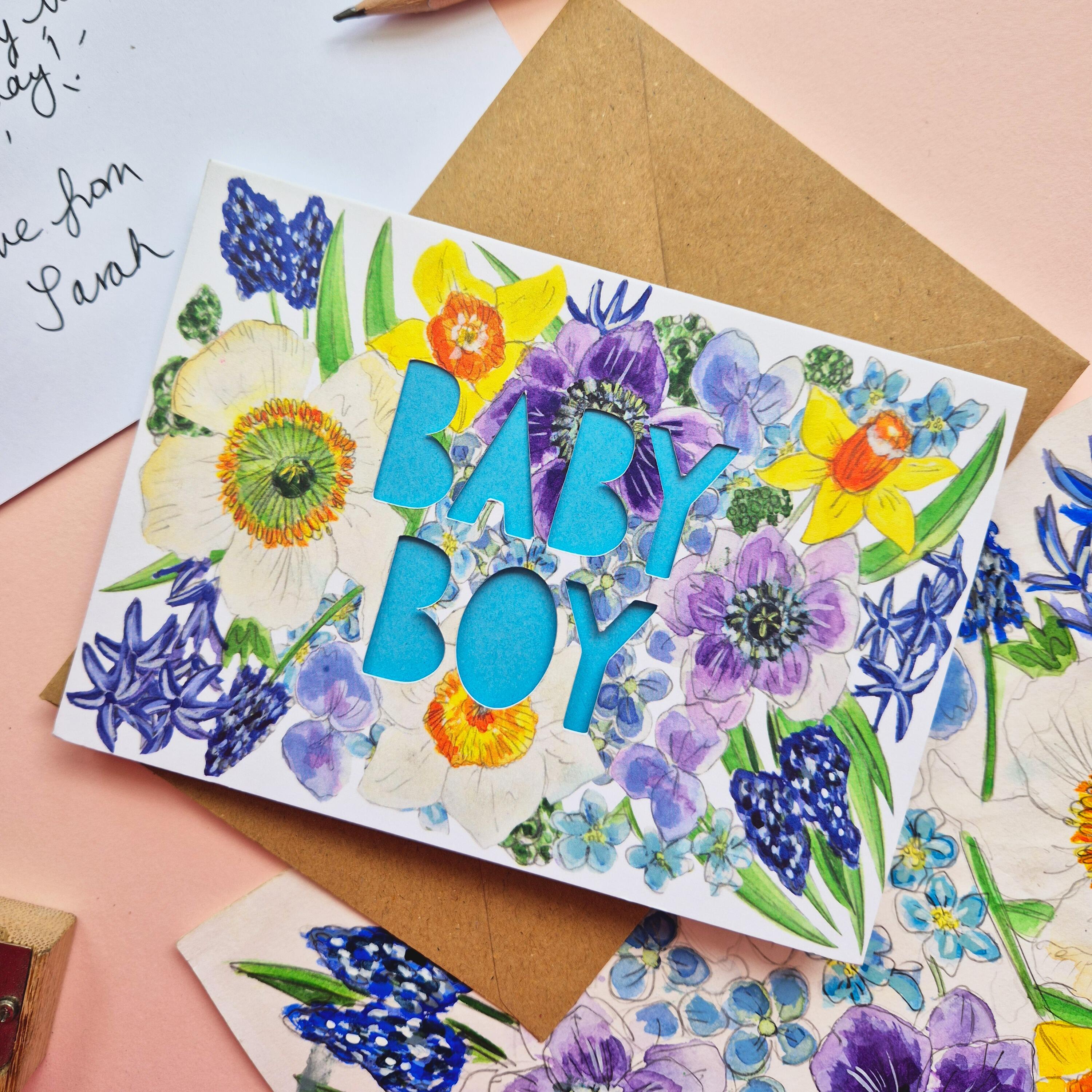 Floral Illustration card with die cut Baby Boy text and bright blue paper liner
