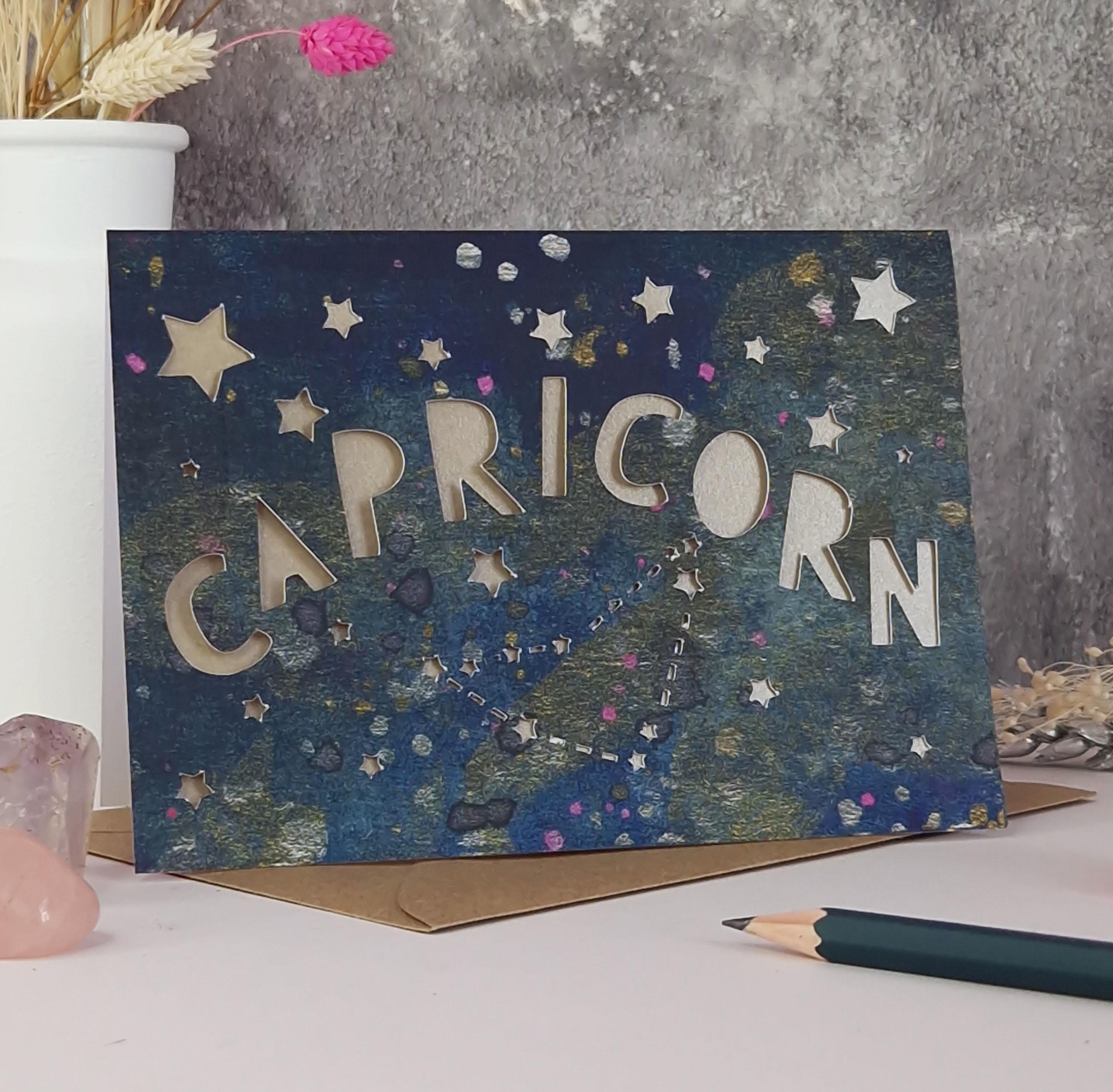 Midnight Blue printed card with papercut text that says 'Capricorn' and a mink pearl liner
