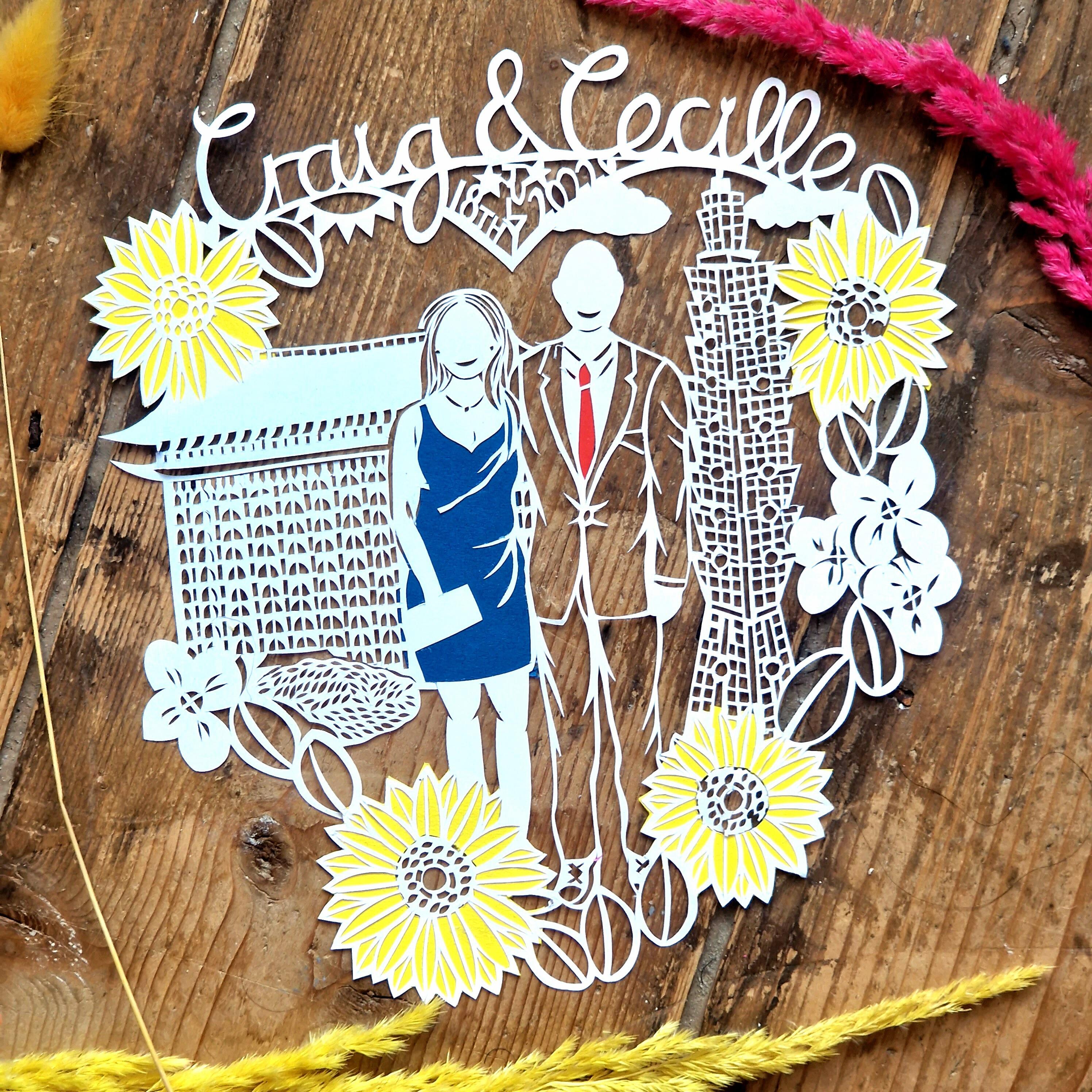 Wedding paper cut featuring bride and groom at at forest wedding, with flowers around the outside