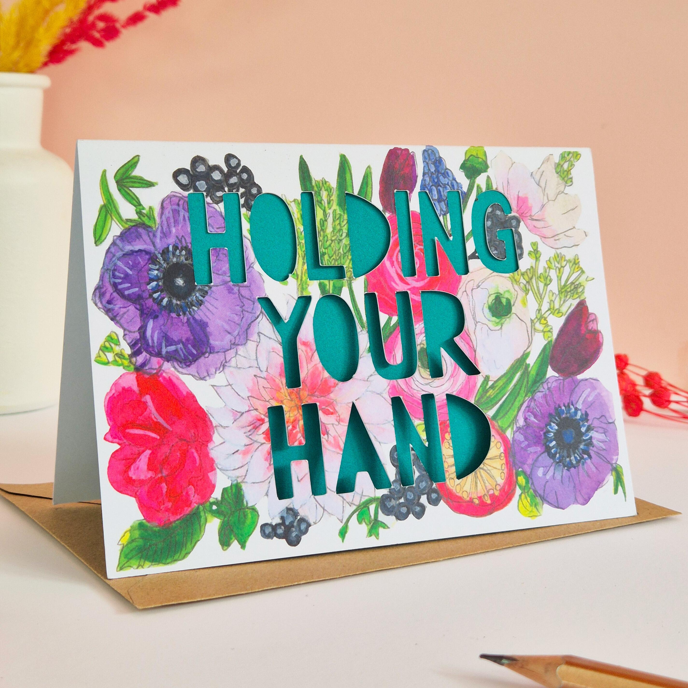 Bright floral illustration card with Holding Your Hand paper cut text and green paper liner