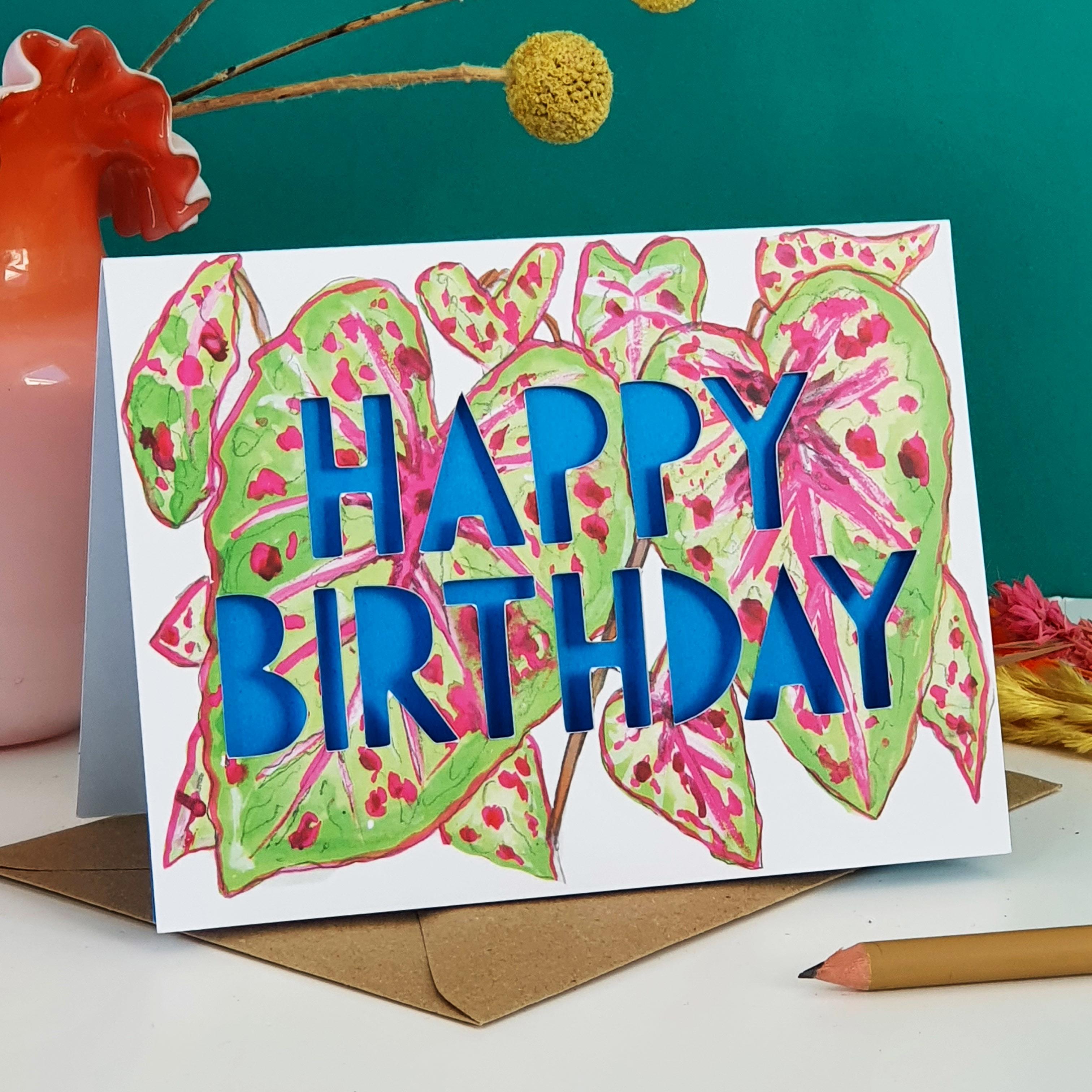 Paper cut card with 'Happy Birthday' typography on a printed spotty calathea 350 gsm card with bright blue liner.
