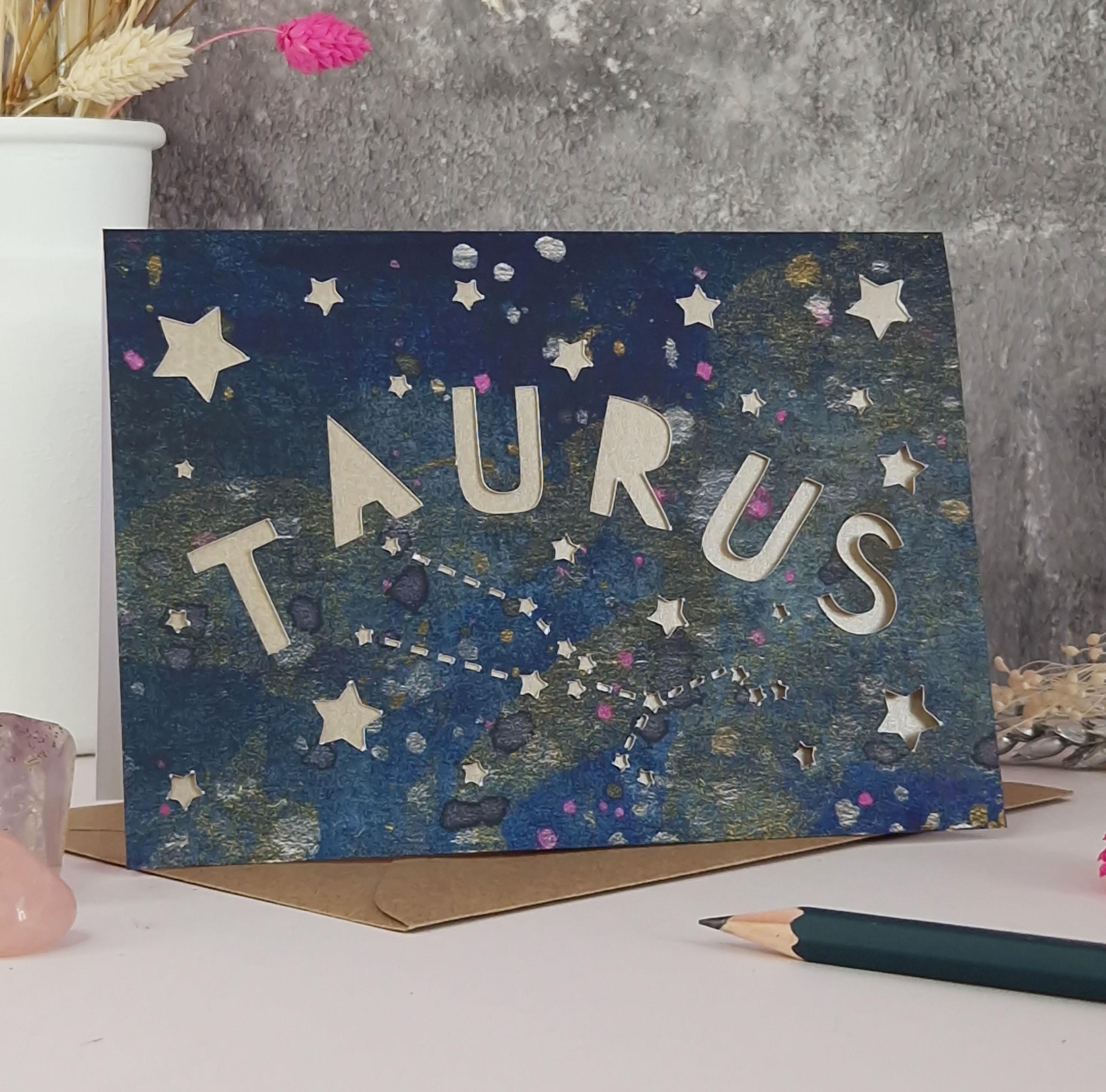 Midnight Blue printed card with papercut text that says 'Taurus' and a mink pearl liner