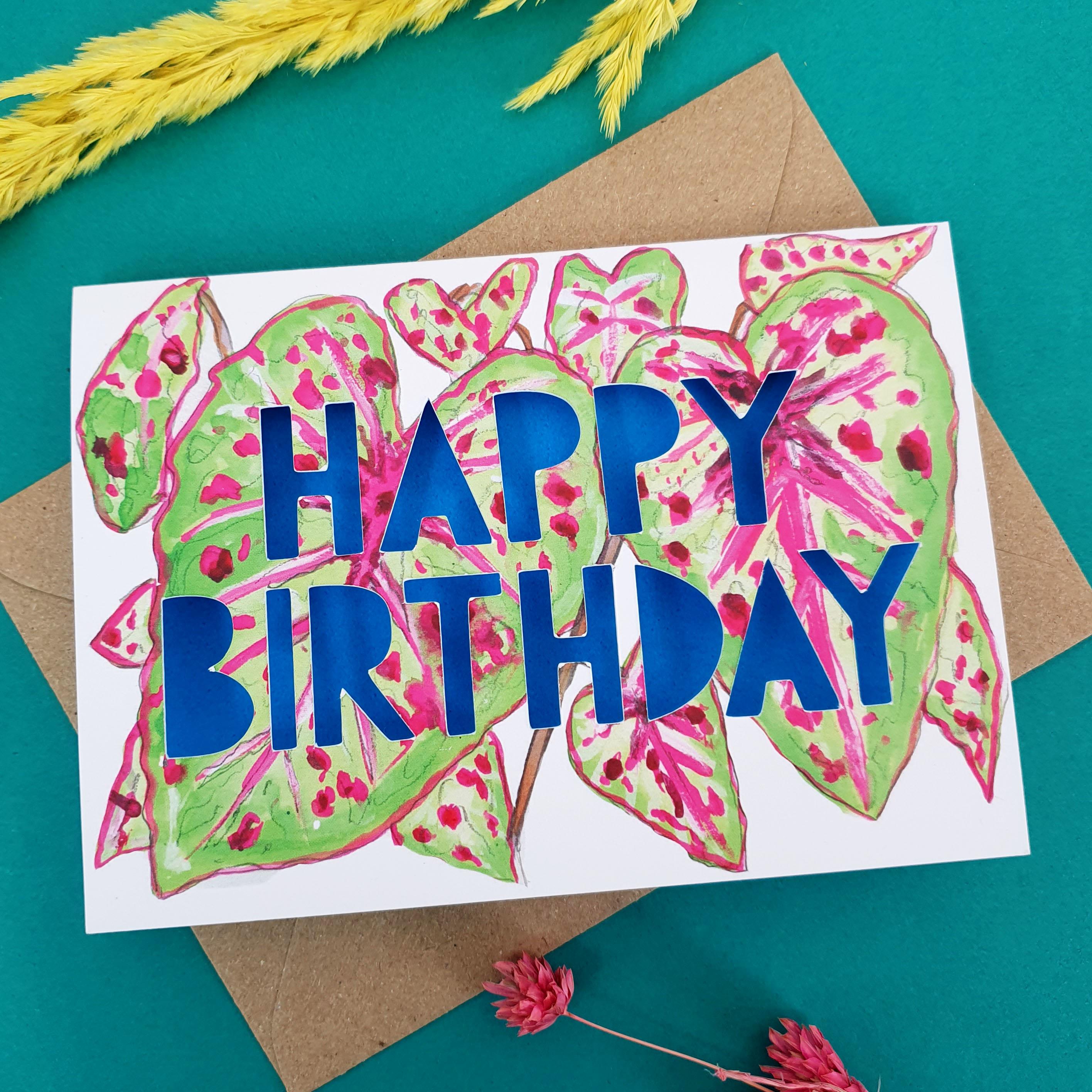 close up of Paper cut card with 'Happy Birthday' typography on a printed spotty calathea 350 gsm card with bright blue liner.