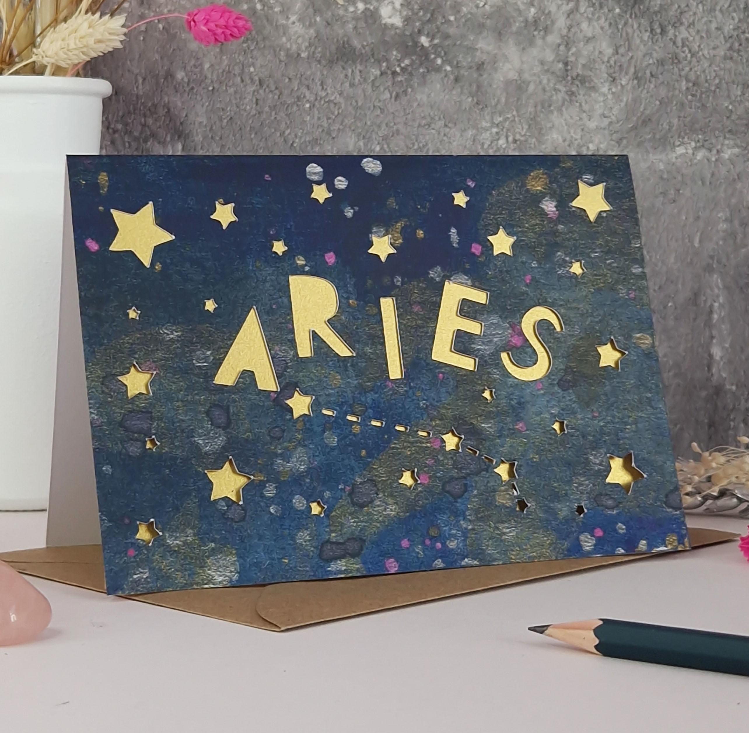Midnight Blue printed card with papercut text that says 'Aries' and a gold pearl liner