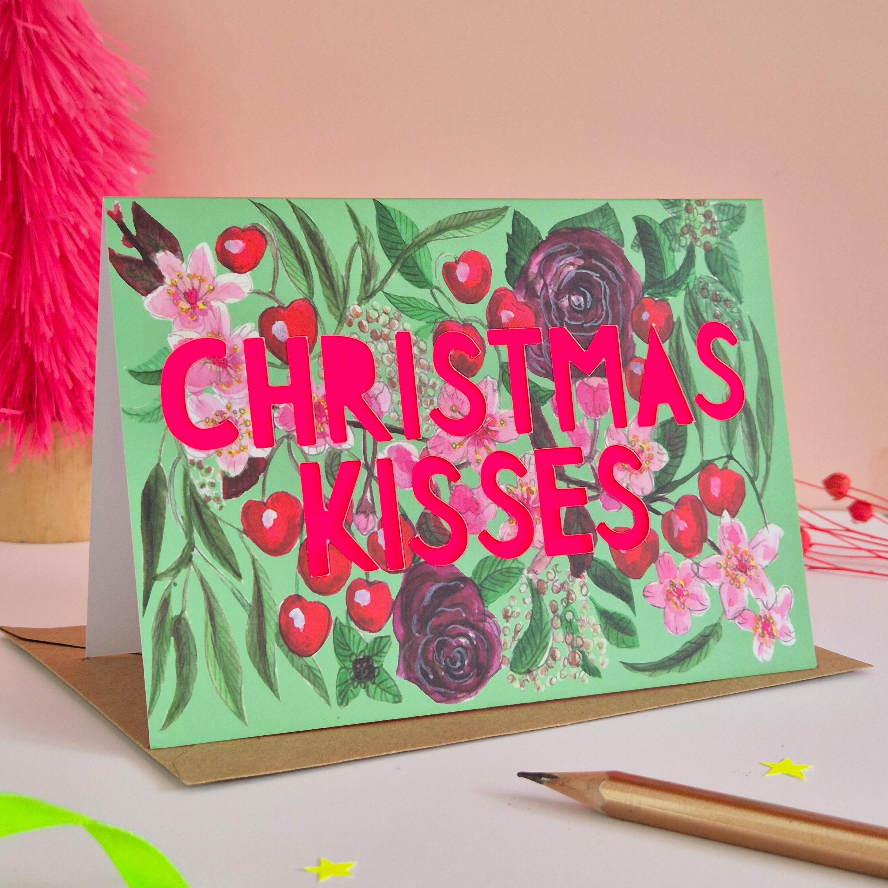 Cherry Illustration card with green background colour and neon pink Christmas kisses die cut text