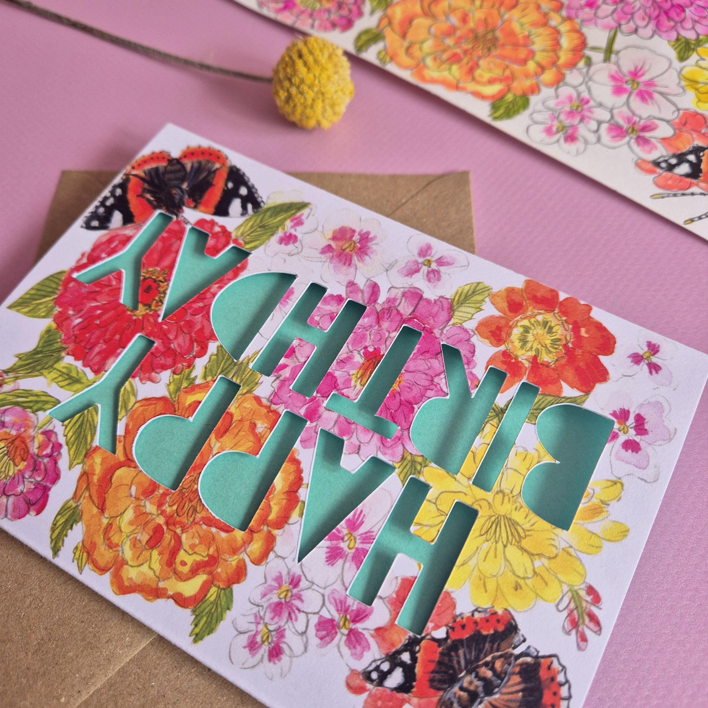 Close up of Red Admiral and floral print butterfly card with turquoise paper cut text