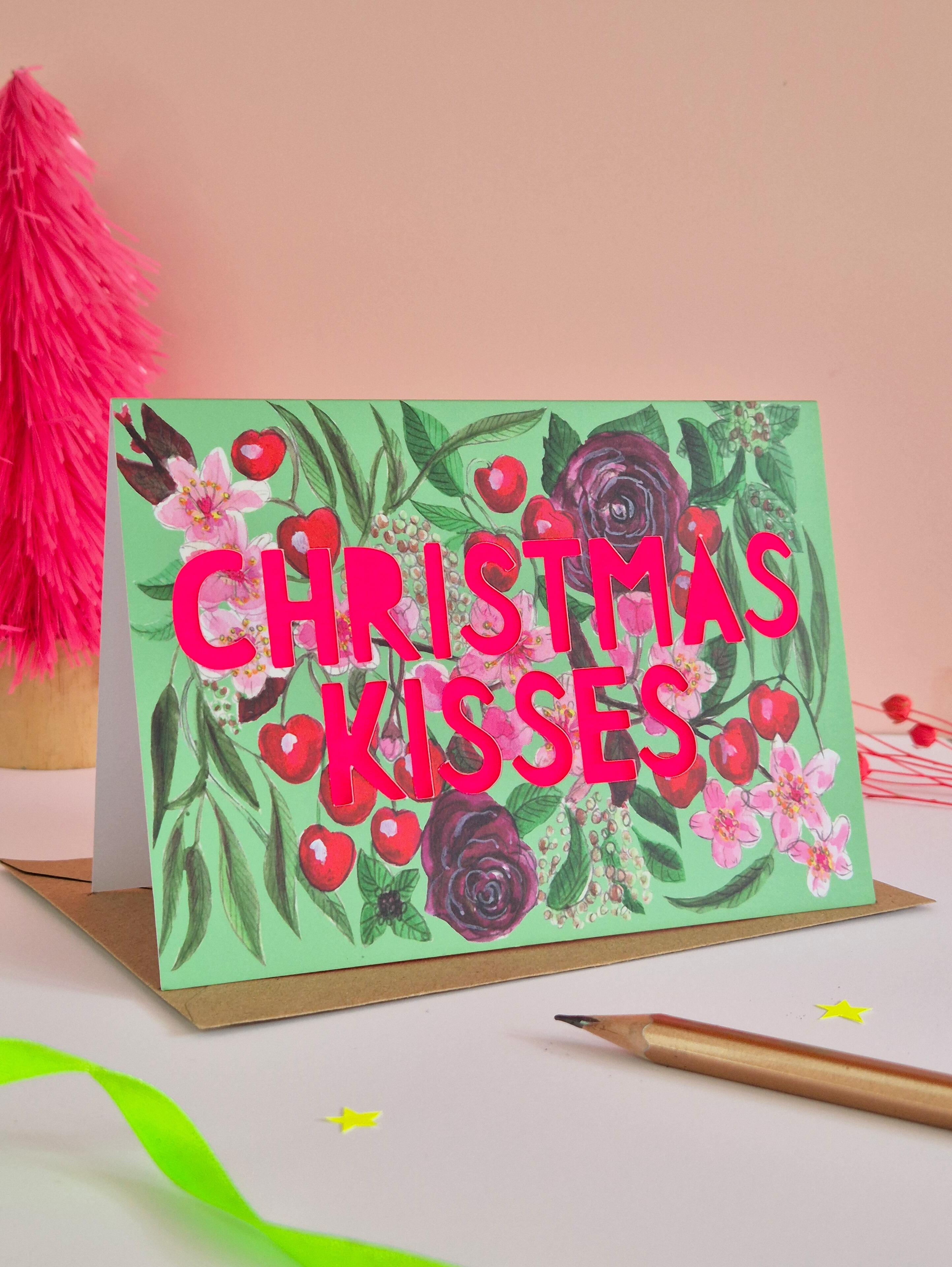 Cherry Illustration card with green background colour and neon pink Christmas kisses die cut text