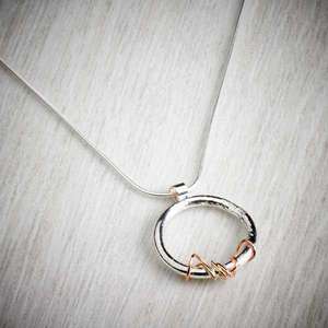 Ivy Twist Circle pendant, silver & gold details by Sally Ratcliffe, image property of THE JEWELLERY MAKERS