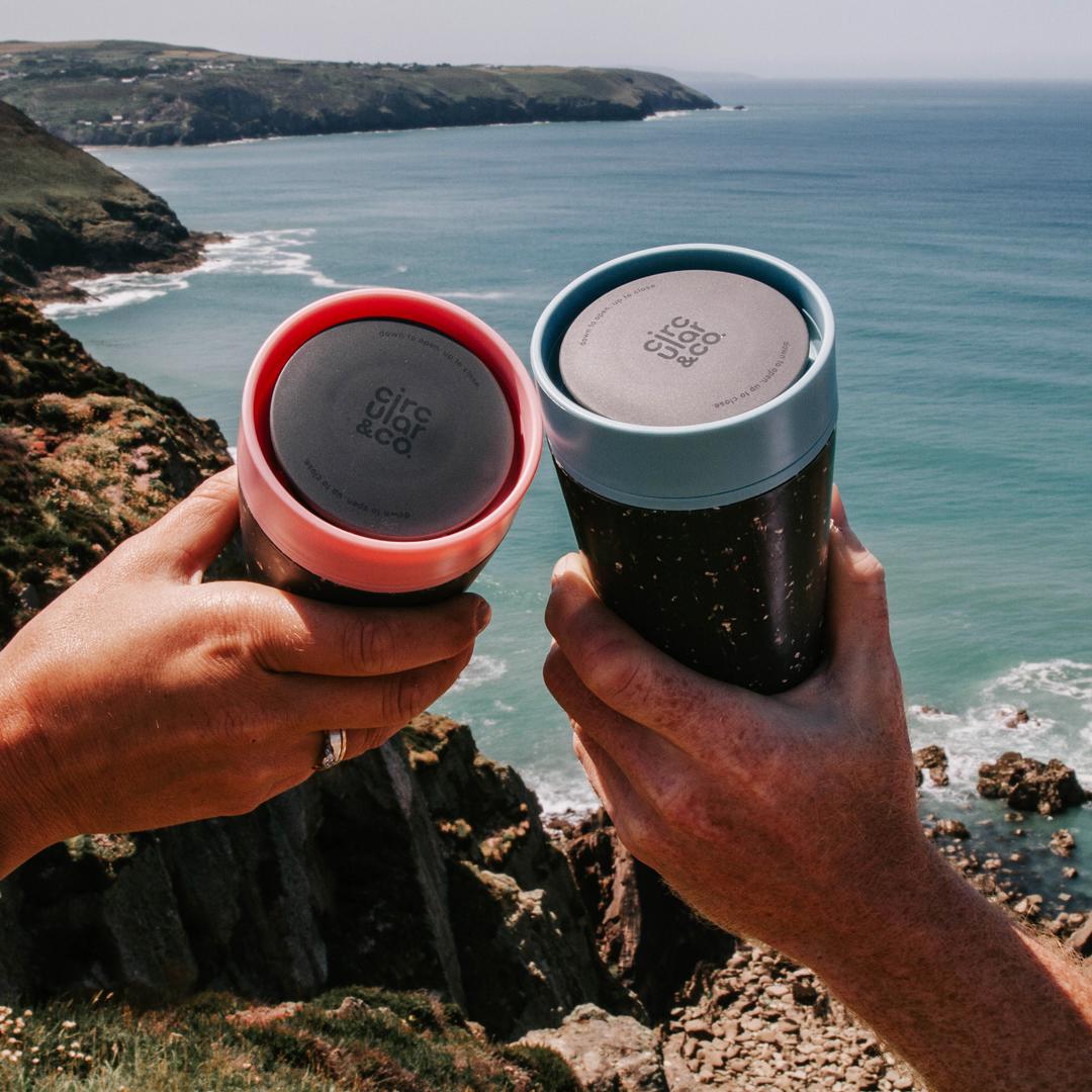 Circular&Co. Coffee Cup - 12oz - Black & Giggle Pink in use at beach
