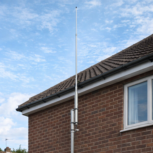 Sirio CX‑4 4m base station antenna mounted on brick house exterior, aluminium mast with DC‑ground protection, clear blue sky background.
