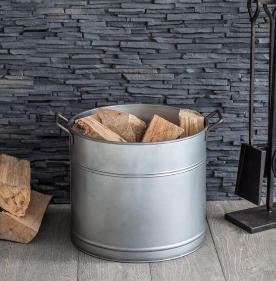 detail of galvanised steel log buckets for inddor wood storage by fireplace