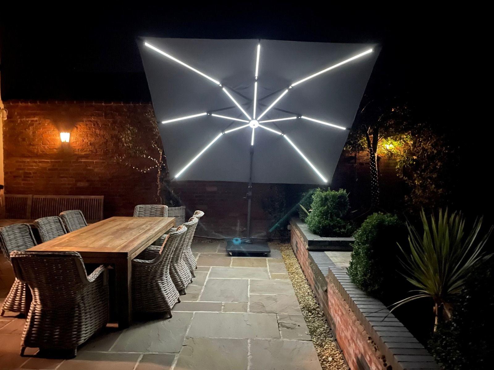 led lights on garden cantilever parasol tilted over dining set grey modern contemporary design