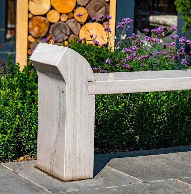 detail seat and leg of cream sandstone garden bench