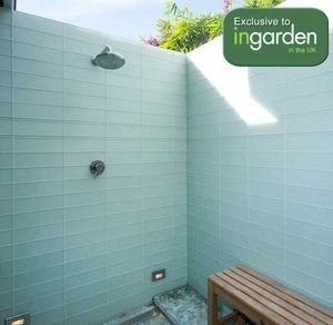 outdoor shower mixer and shower head in garden tiled enclosure