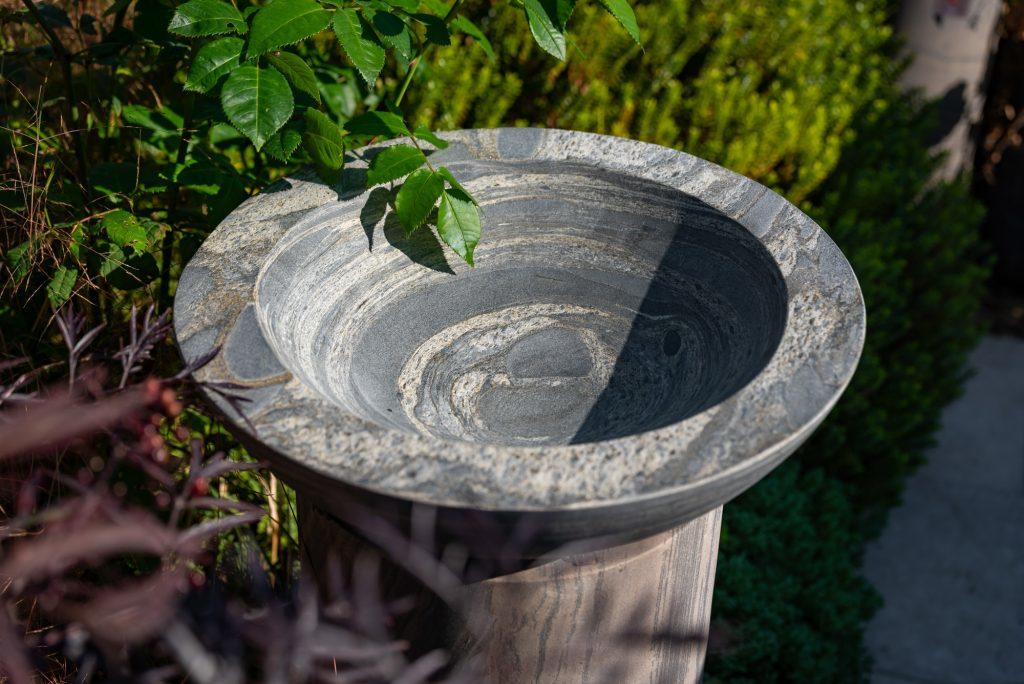 sandstone grey bird bath on natural stone plinth in contemporary grey