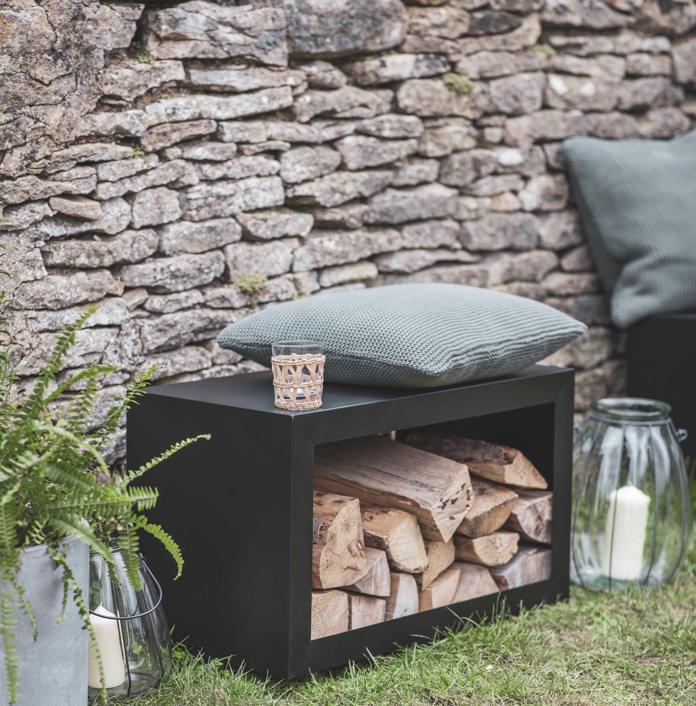 large modern garden outdoor log store in black iron metal that is also a garden bench seating