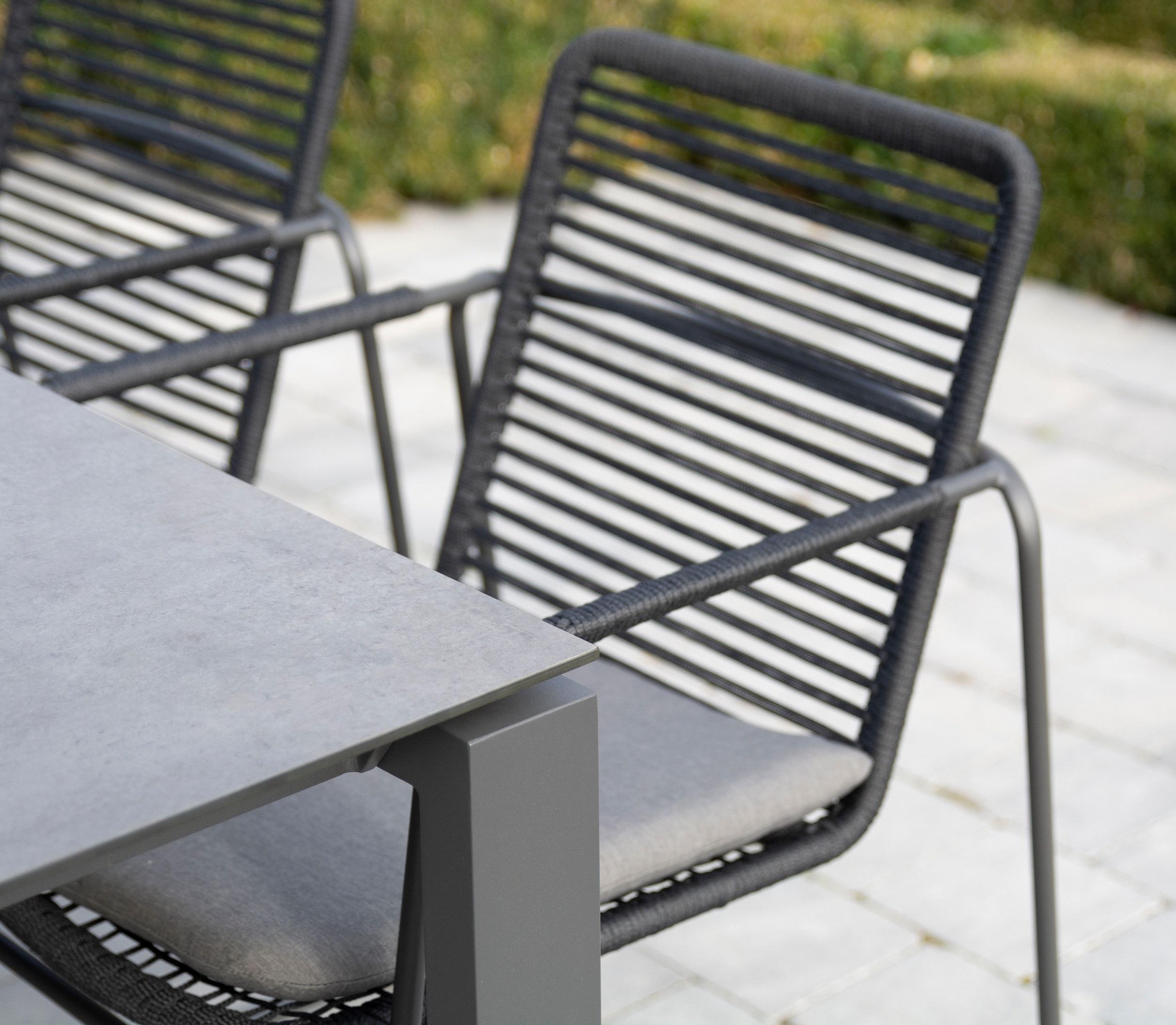 detail of slimline grey aluminium metal garden stackable dining chairs and rope weave