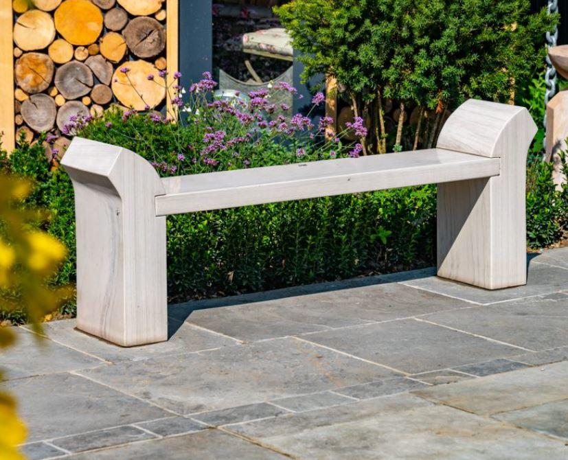 cream stone garden bench in natural sandstone with curved arms