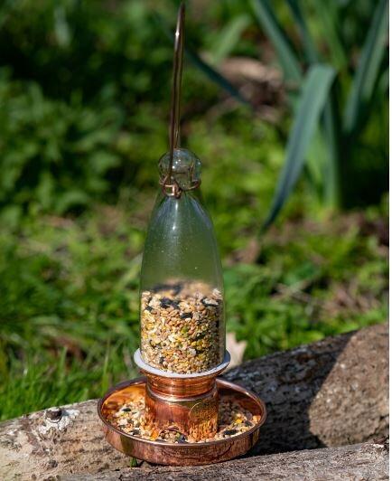 modern bird feeder in glass and copper for outdoor use
