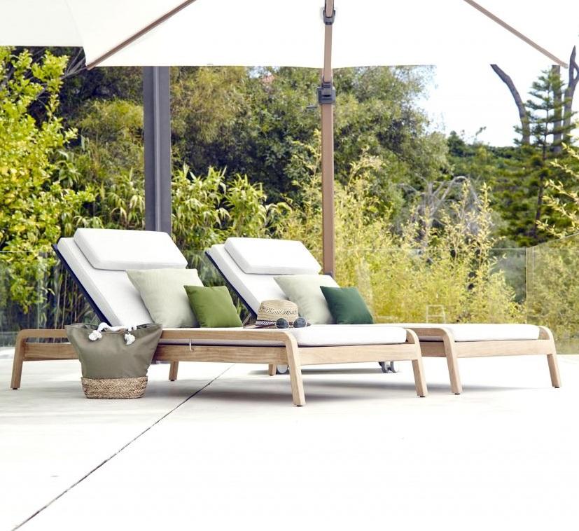 pair of high grade luxury teak sun loungers or sunbeds for gardens , pools, terraces with weatherproof cushions