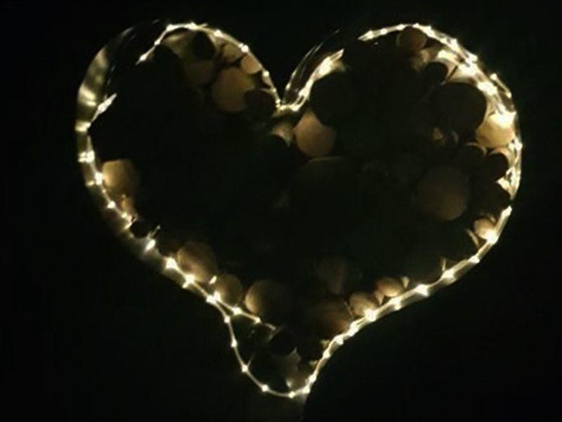 heart shaped garden log store night time with hung lights