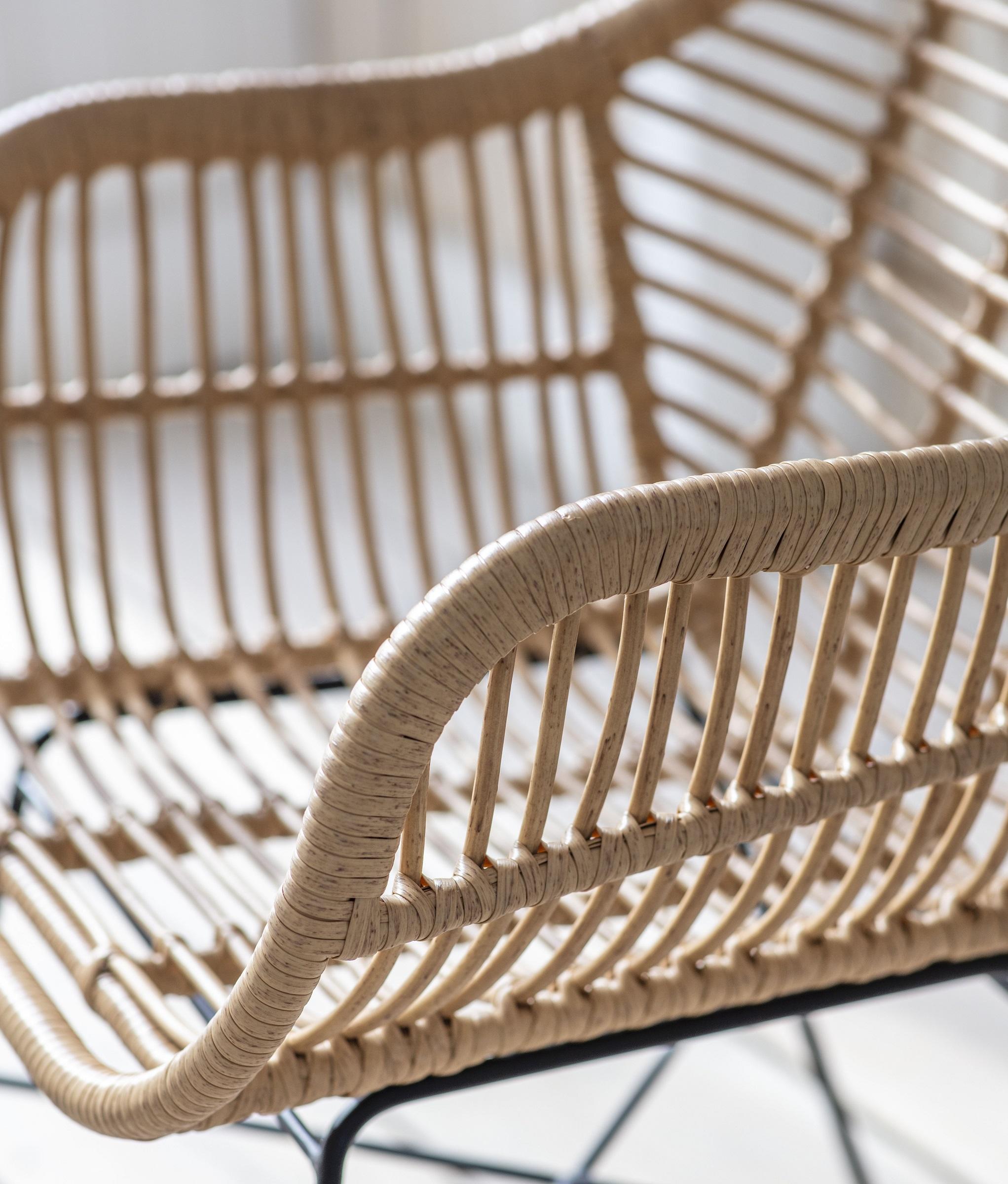 detail of all weather bamboo rattan weave garden dining chair in conservatory or garden room