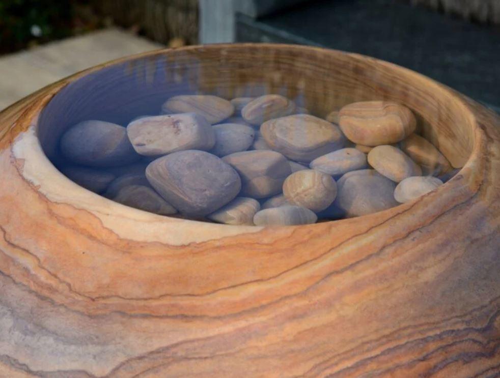 infinity pool topped sphere in natural rainbow sandstone with pebbles