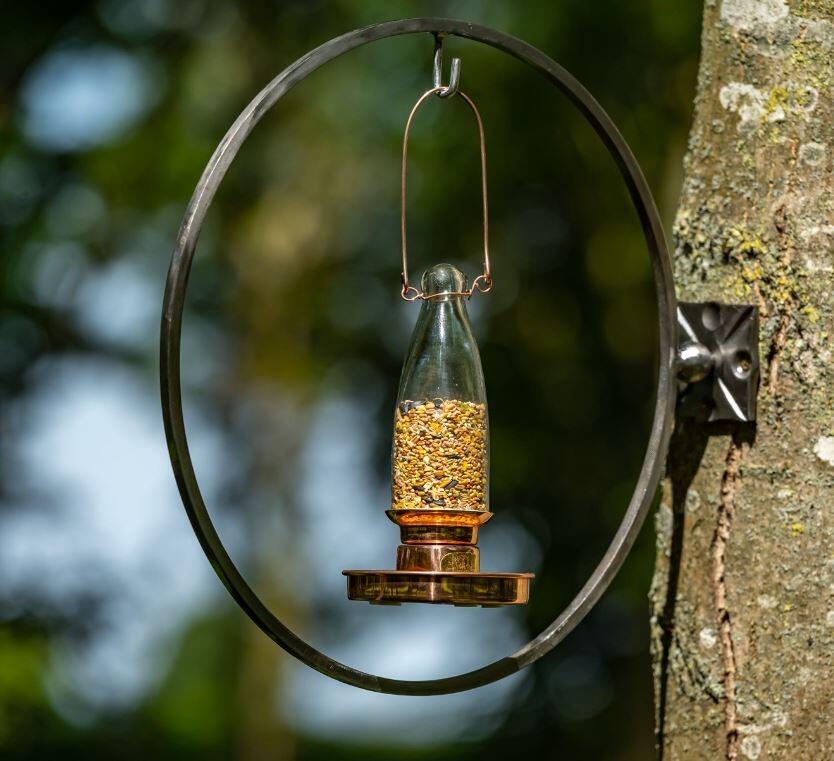 bird feeder in copper and glass for modern gardens and outdoor use